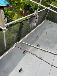 横浜市戸塚区にて屋根修理（スレートからガルマリウム鋼板にカバー工法）既存屋根の上からルーフィングを張り、新しい屋根材本体を葺いていきます
